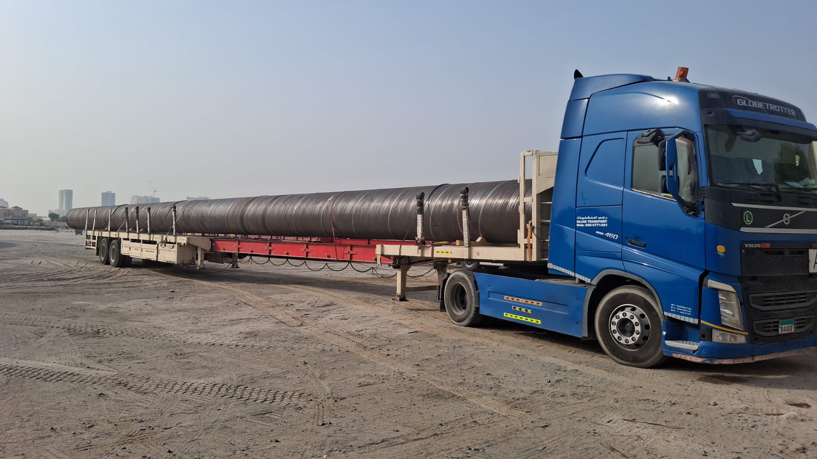 Long steel pipe sections on an extended flatbed trailer